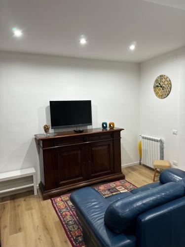a living room with a blue couch and a flat screen tv at A casa mia - Holiday House in Caltanissetta