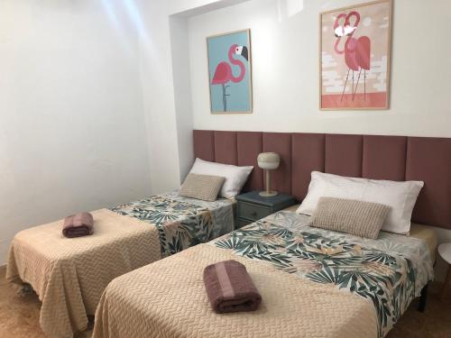 a room with two beds with towels on them at Vernisa Apartamento Numero Uno in Playa de Gandia