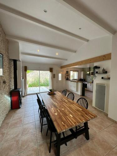 une cuisine et une salle à manger avec une table et des chaises en bois dans l'établissement Au bout de l'impasse, à Saint-Sulpice-de-Royan