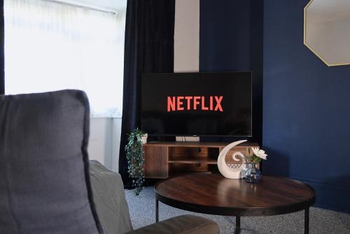 a living room with a tv and a coffee table at Stylish Newcastle Stay- Free Private Parking - Ideal for Groups, Families & Work Stays in Newcastle upon Tyne