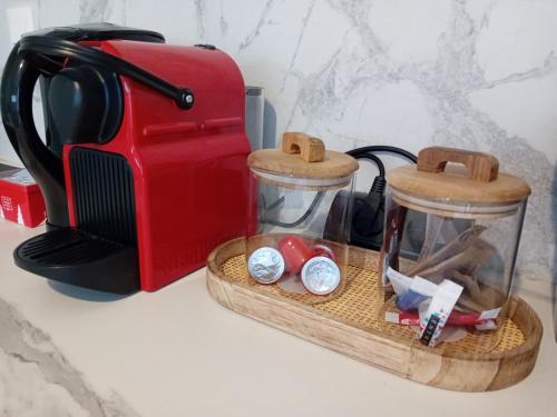 un comptoir de cuisine avec un grille-pain et deux bocaux en verre dans l'établissement Le Benvegnu, à Chambéry