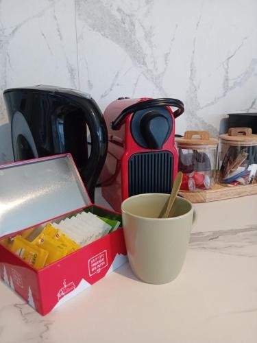 une tasse et une boîte avec une cuillère à côté d'une tasse dans l'établissement Le Benvegnu, à Chambéry