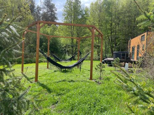 a hammock in the middle of a yard at Tiny Silent House River in Zblewo