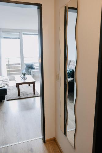 a sliding glass door in a living room with a table at Apartment Gelassenheit Geyersberg - dein exklusiver Ort zum Ankommen & Genießen in Freyung