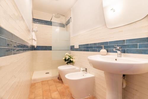 a white bathroom with a sink and a toilet at Villa La Lespa W-Pool Biliardo and Lake View in Casa SantʼAndrea