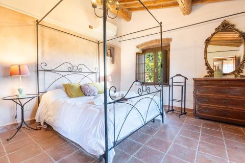 a bedroom with a bed and a dresser and a mirror at Villa La Lespa W-Pool Biliardo and Lake View in Casa SantʼAndrea