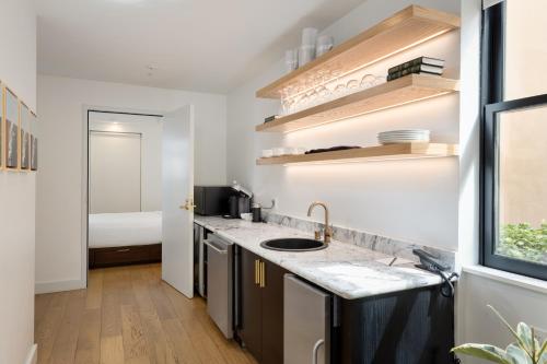 a kitchen with a sink and a bed in a room at The Guild Hotel San Diego Downtown, a Marriott Tribute Portfolio Hotel in San Diego