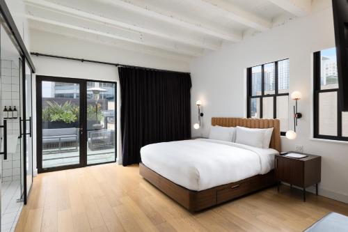 a bedroom with a large bed and a large window at The Guild Hotel San Diego Downtown, a Marriott Tribute Portfolio Hotel in San Diego
