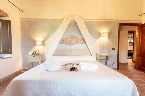 a white bed with a plate of food on it at Villa La Lespa W-Pool Biliardo and Lake View in Casa SantʼAndrea