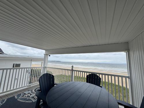 a porch with a table and chairs and a view of the beach at The Beach House in Old Orchard Beach