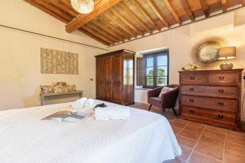 a bedroom with a white bed and a dresser at Villa La Lespa W-Pool Biliardo and Lake View in Casa SantʼAndrea