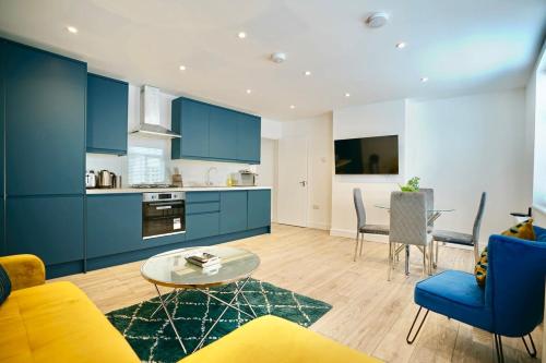 a living room with blue cabinets and a table at Trinity Apartments - 2 Bed Apartment - Spacious - Modern - 30 Seconds from High Street in Huntingdon