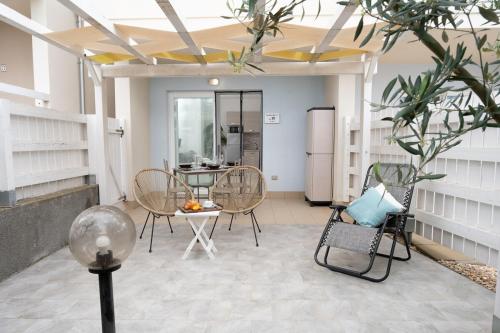 a room with chairs and a table and a refrigerator at Green Villetta with a pool in Viddalba