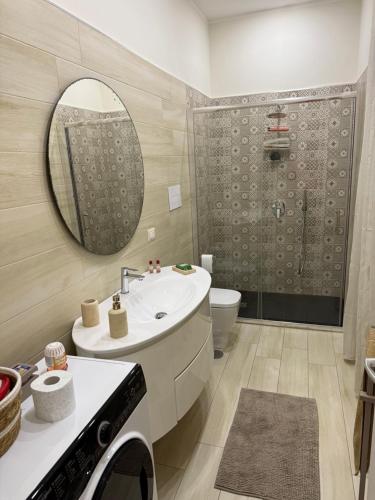 a bathroom with a sink and a toilet and a mirror at Appartamento il giglio in Terracina