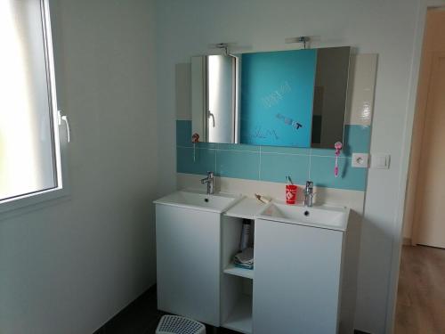 une salle de bain avec un lavabo blanc et un miroir dans l'établissement Belle maison entre mer et campagne, à Plouzané