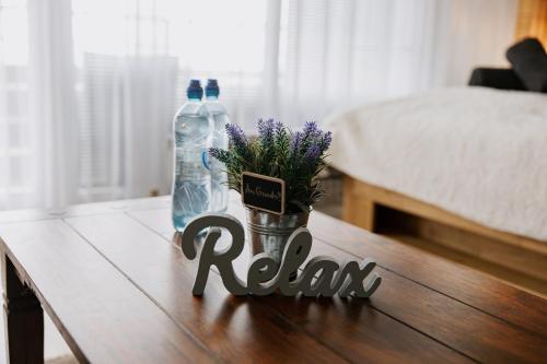 a table with two bottles of water and flowers on it at Apartment Gelassenheit Geyersberg - dein exklusiver Ort zum Ankommen & Genießen in Freyung