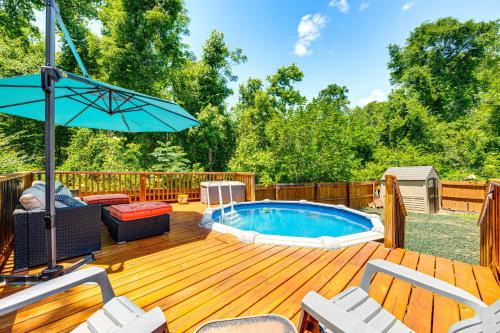 a pool on a wooden deck with chairs and an umbrella at 4 Mi to FSU Family Home with Pool and Yard in Tallahassee