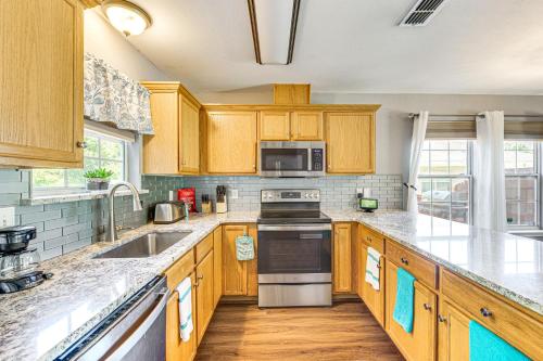 a kitchen with wooden cabinets and stainless steel appliances at 4 Mi to FSU Family Home with Pool and Yard in Tallahassee