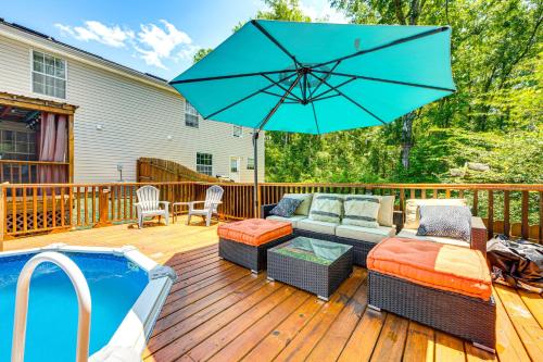 a patio with a couch and an umbrella next to a pool at 4 Mi to FSU Family Home with Pool and Yard in Tallahassee