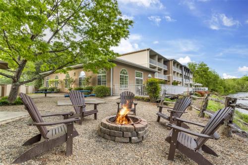 a fire pit with three chairs in front of a building at Best Western Plus River Escape Sylva / Dillsboro in Dillsboro