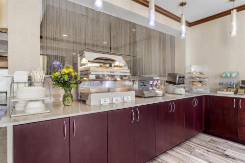 a kitchen with purple cabinets and flowers on a counter at Best Western Plus River Escape Sylva / Dillsboro in Dillsboro