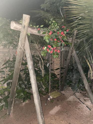 a wooden cross with a bunch of flowers on it at Sítio Estrela da Manhã Hospedagem e Lazer in Palmeiras