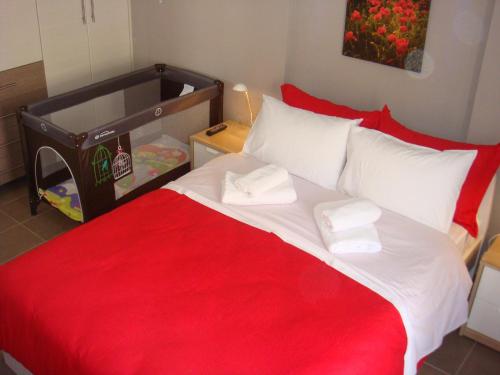 a red and white bed with two towels on it at Sandra's Sea View at Sounio in Sounio