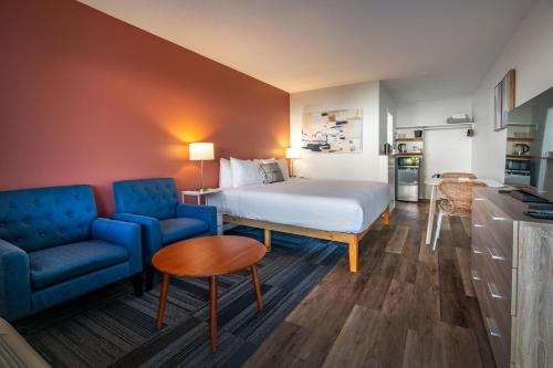 a hotel room with a bed and a blue couch at Okanagan Lakefront Resort in Penticton