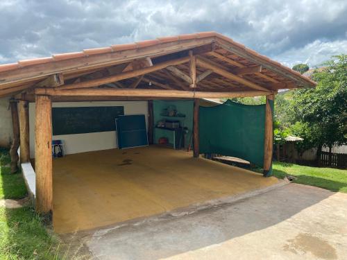 a pavilion with a wooden roof on a patio at Chácara Namorada do Sol - Pousada e Camping in Guaxupé
