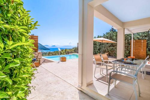 a patio with a table and chairs and a pool at Villa Ira Lefkas in Póndi
