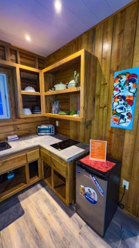 a kitchen with wooden cabinets and a refrigerator at Toucan Hill Lodge in Bocas del Toro