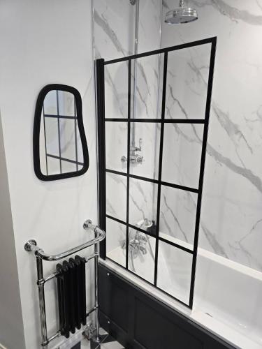 a bathroom with a shower with a mirror at Luxury central apartment w/ 3 beds + 24hr check-in in Aberdeen