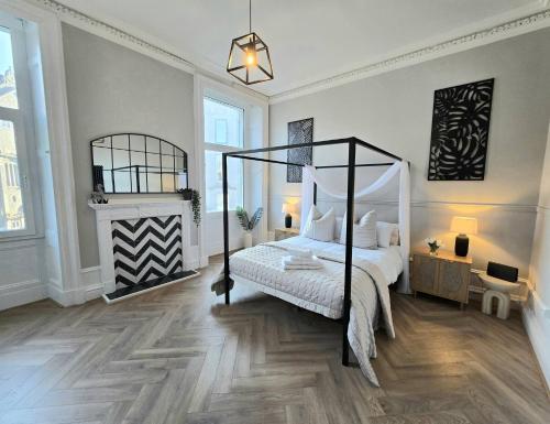 a bedroom with a canopy bed and a fireplace at Luxury central apartment w/ 3 beds + 24hr check-in in Aberdeen