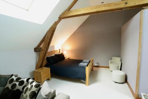 - une chambre mansardée avec un lit et un canapé dans l'établissement Fantastic Holiday Home 5 ensuite bedrooms Pool No Pets, à Désertines