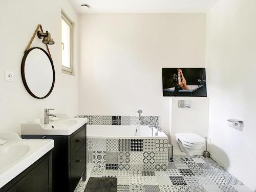 a bathroom with a sink and a toilet and a mirror at Villa du Littoral in Grimaud