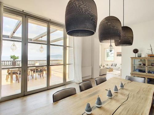une salle à manger avec une table et une vue sur l'océan dans l'établissement Villa du Littoral, à Grimaud