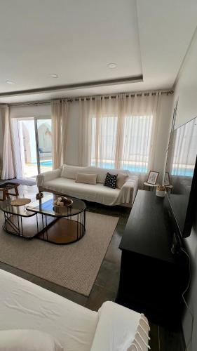 a living room with a couch and a table at Villa Le Domaine Djerba Piscine Chauffée sans vis à vis in Mezraya