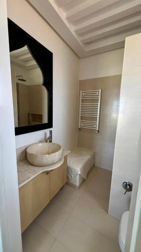 a bathroom with a sink and a large mirror at Villa Le Domaine Djerba Piscine Chauffée sans vis à vis in Mezraya