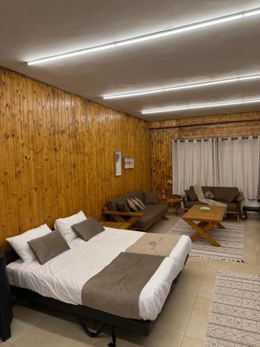 a bedroom with a large bed and a living room at Oak Farm مزرعة البلوط in Ajloun