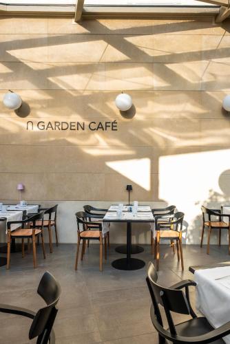 a restaurant with tables and chairs and a sign that reads garden cafe at Eurostars Matera La Suite in Matera