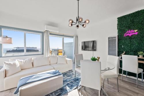 a living room with a white couch and a table and chairs at Luxury Beachside Gem Walk to Beach Ocean Views in Manhattan Beach
