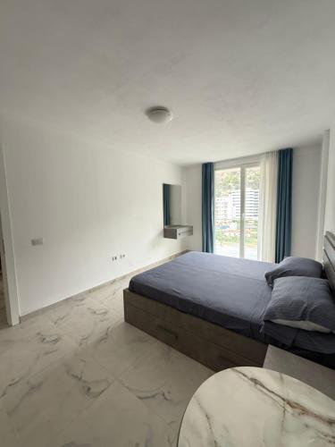 ein Schlafzimmer mit großem Bett und Fenster in der Unterkunft 9apartaments shengjin in Shëngjin