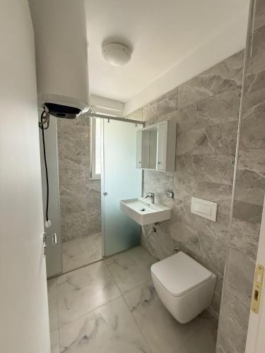 ein Badezimmer mit Toilette und Waschbecken in der Unterkunft 9apartaments shengjin in Shëngjin