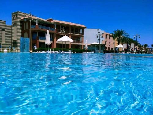 a large pool of blue water in front of a hotel at Porto Matrouh Majestic in Marsa Matruh