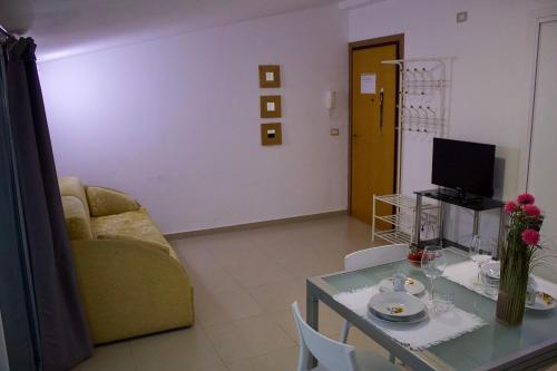 a living room with a couch and a table at Evergreen Terrace in Giardini Naxos