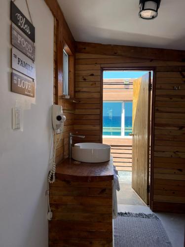 a bathroom with a sink on a wooden wall at The Sea Cliff Hotel Resort & Spa in Port Antonio
