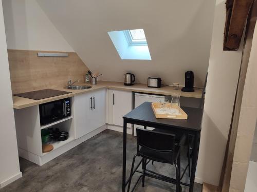 une petite cuisine avec une table et un évier dans l'établissement Studio style LOFT centre-ville, à Vierzon