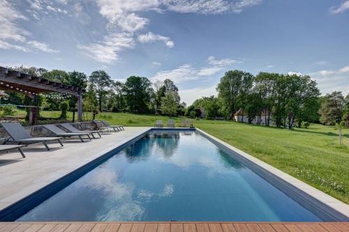 - une piscine dans une cour avec 2 tables de pique-nique dans l'établissement Domaine des Forges de la Vache, à Raveau