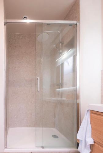 une douche avec une porte vitrée dans une salle de bain dans l'établissement 3 pieces au coeur de la piétonne, à Nice