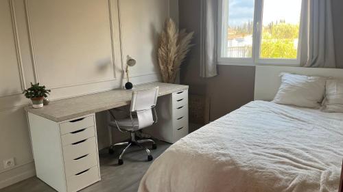 a bedroom with a desk and a bed and a window at Chambre d'hôte dans une maison cosy in Saint-Martin-de-Crau